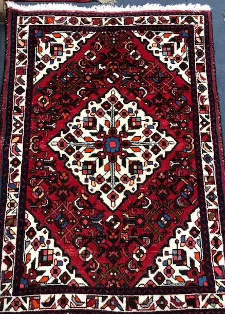 A Persian red and cream lozenge pattern rug 150 x 108cm.